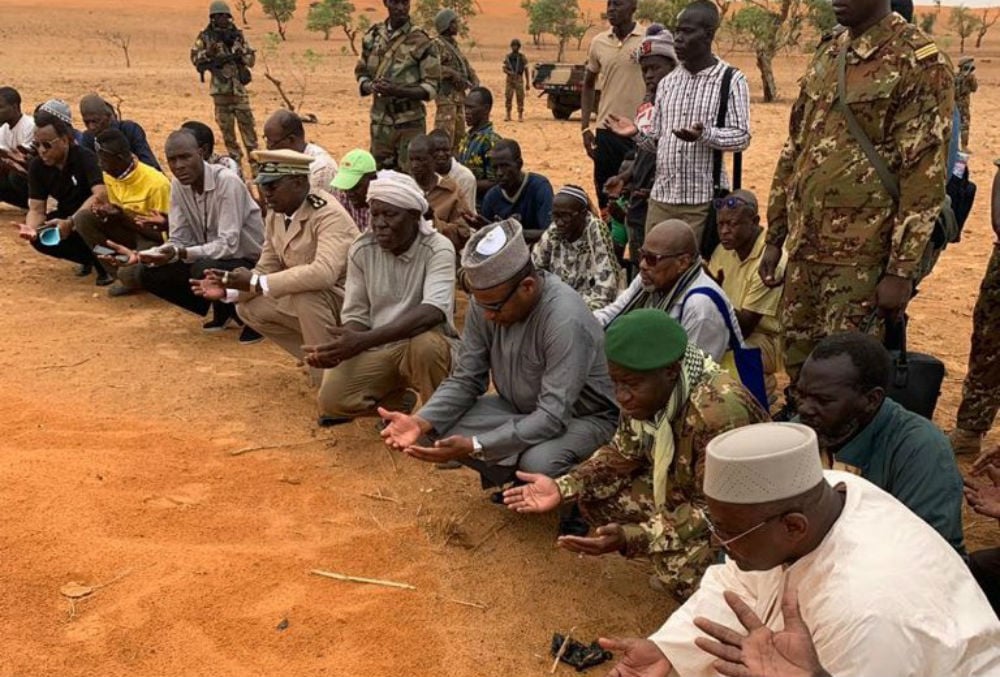 Boubou Cissé, le Premier ministre malien (au centre), prie sur les tombes des victimes de la tuerie de Sobane, lors d'une visite sur place le 11 juin 2019. © DR / Primature du Mali