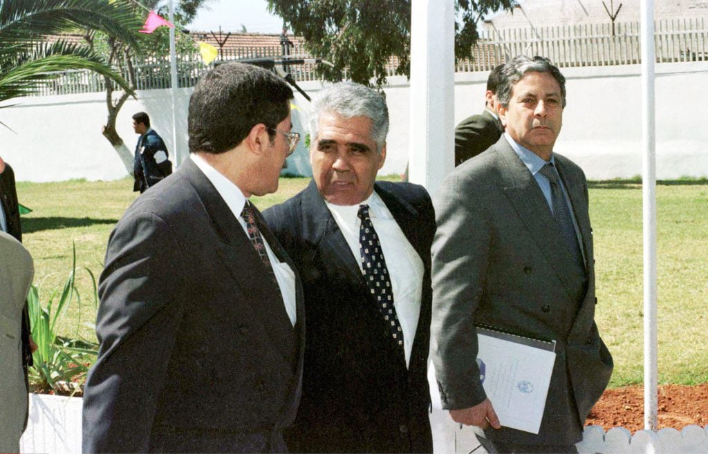 Mohamed Betchine (au centre), ami proche de Zéroual, en conversation avec Ahmed Ouyahia, en 1998. © NEW PRESS/SIPA