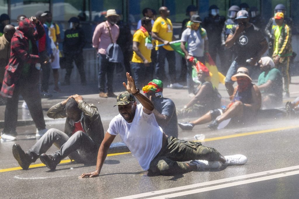 Des manifestants de la diaspora camerounaises se font disperser avec des canons à eau alors qu'ils protestent devant l'hôtel où réside Paul Biya, à Genève, le 29 juin 2019. © MARTIAL TREZZINI/AP/SIPA