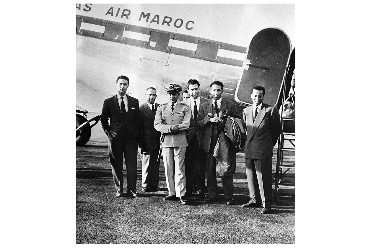 De g. à dr., Ahmed Ben Bella, Mohamed Khider, le prince héritier marocain Moulay Hassan, Hocine Aït Ahmed, Mohamed Boudiaf et Mostefa Lacheraf, à l'aéroport de Rabat, le 22 octobre 1956, quelques heures avant que l'avion dans lequel ont embarqué les cinq leaders algériens ne soit détourné par la France. © BOISSONNADE/AFP