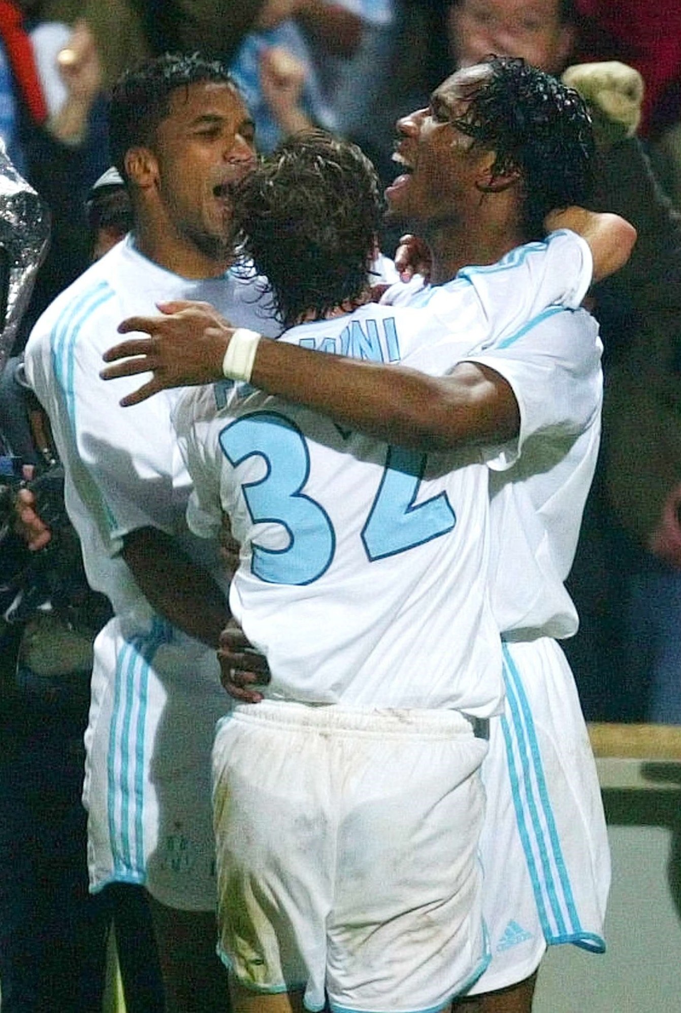 Didier Drogba de Marseille, à droite, et ses coéquipiers Mathieu Flamini et Habib Beye, à gauche, réagissent après le deuxième but de Drogba, lors de leur match de demi-finale de Coupe UEFA contre Newcastle, jeudi 6 mai 2004 à Marseille. © LIONEL CIRONNEAU/AP/SIPA