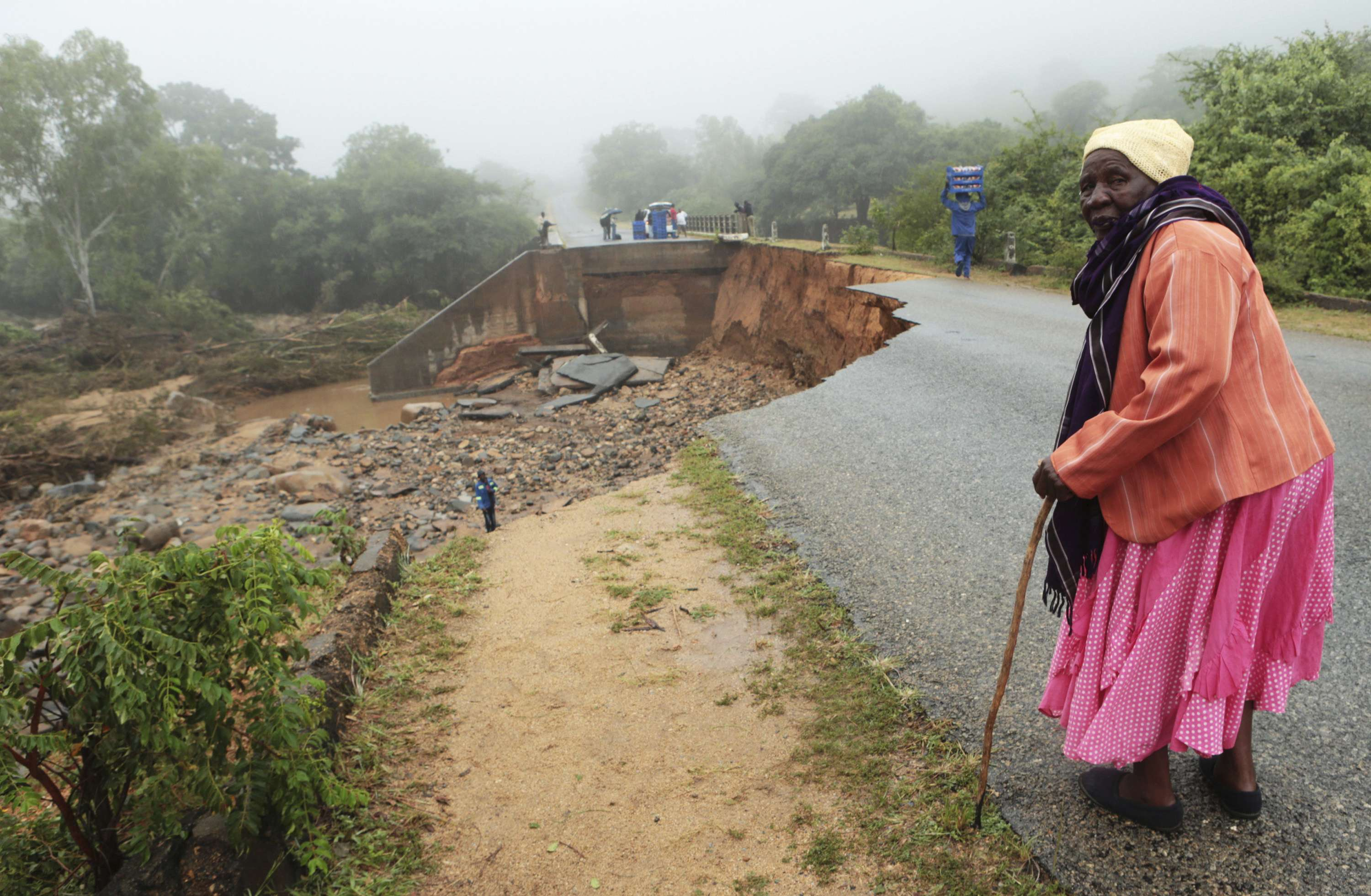 Une vieille dame traverse un pont délabré à Chimanimani, au Zimbabwe après le passage du cyclone Idai. © AP Photo/Tsvangirayi Mukwazhi