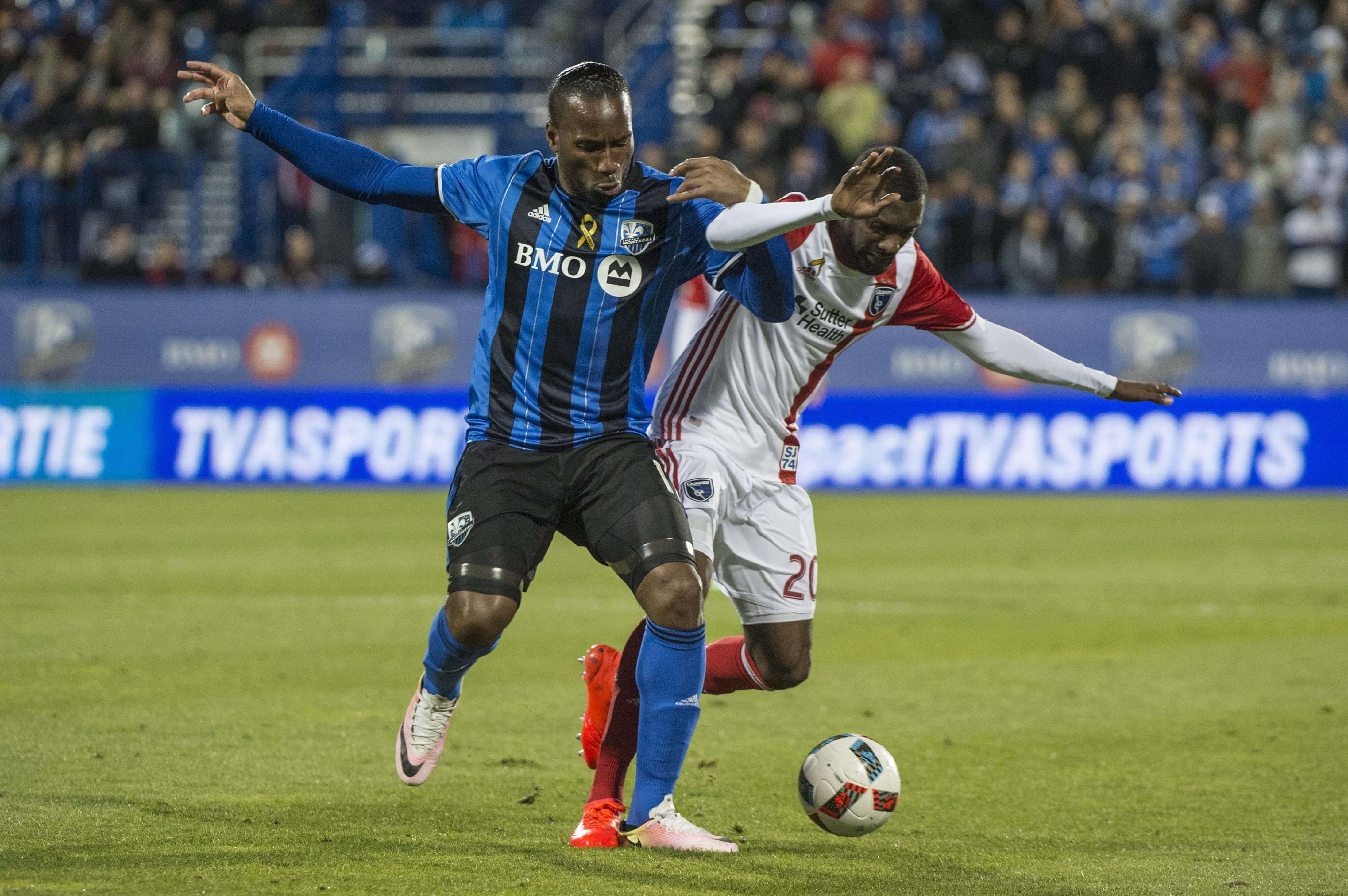 L'attaquant de l'Impact Montréal Didier Drogba, à gauche, et le défenseur des San Jose Earthquakes, Shaun Francis, s'affrontent pour le ballon lors de la deuxième moitié d'un match de soccer de la MLS, le mercredi 28 septembre 2016 à Montreal. © Paul Chiasson/AP/SIPA