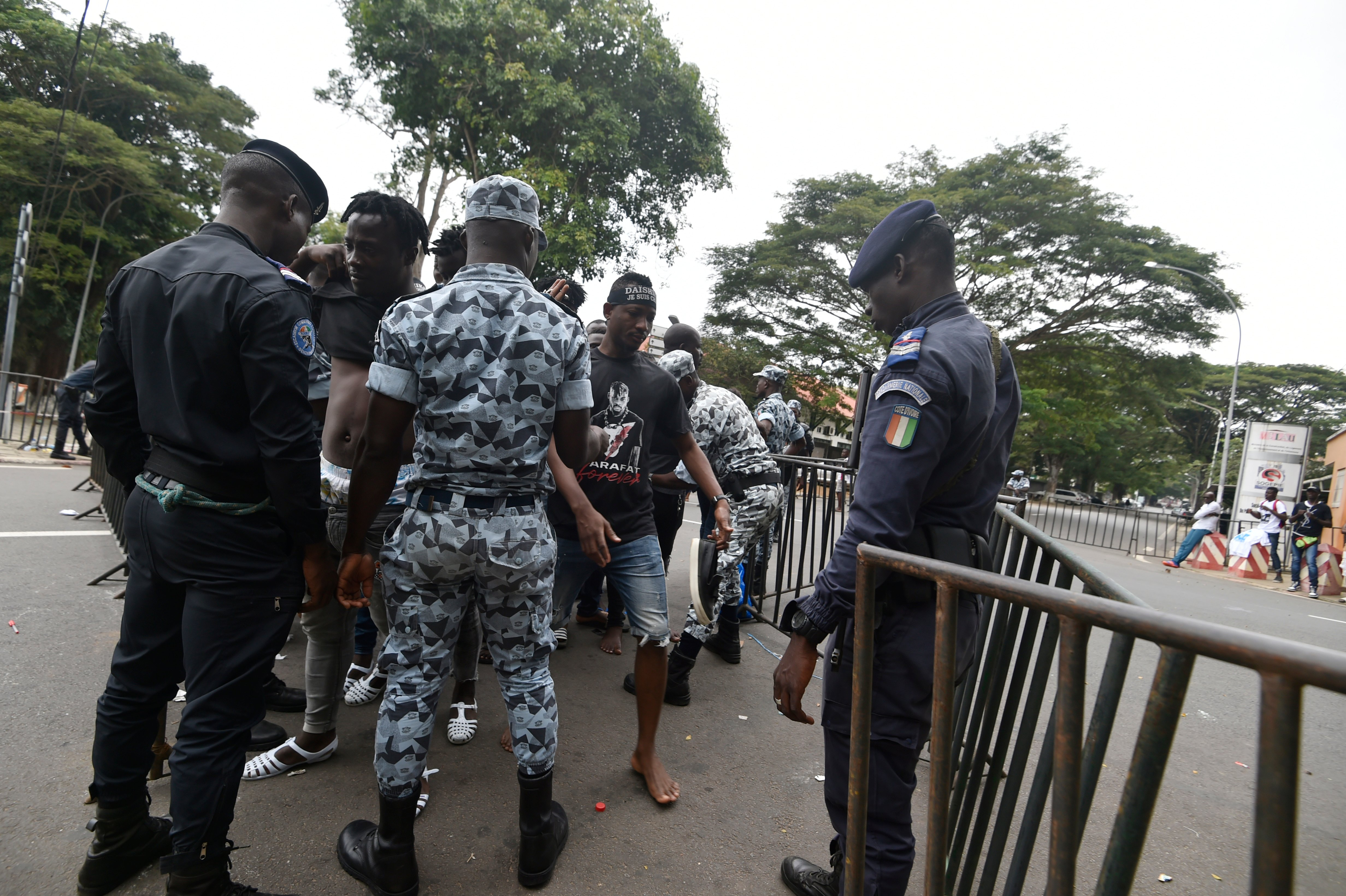 Des policiers et gendarmes ivoiriens contrôlent les fans de DJ Arafat non loin de l'entrée du stade Félix Houphouët-Boigny. © OLIVIER pour JA