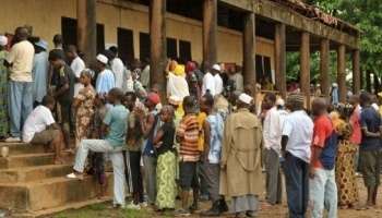 Des électeurs attendent devant un bureau de vote, le 27 juin 2010 à Conakry.