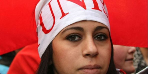 Une Tunisienne tenant le drapeau national durant une manifestation à Marseille en France, le 15 janvier 2011.