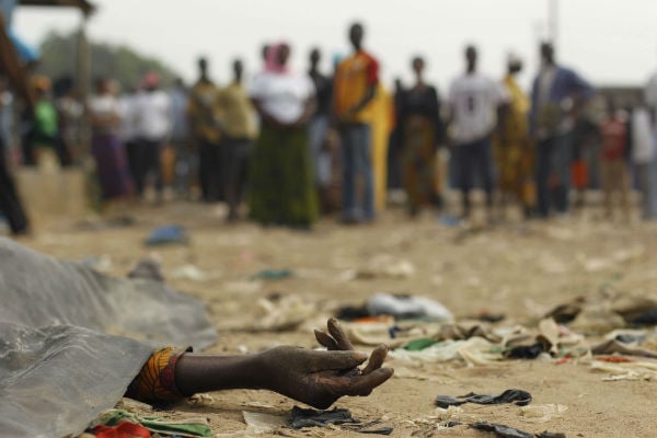 Une foule observe une victime de tirs, en janvier 2011 dans le quartier d'Abobo, à Abidjan.