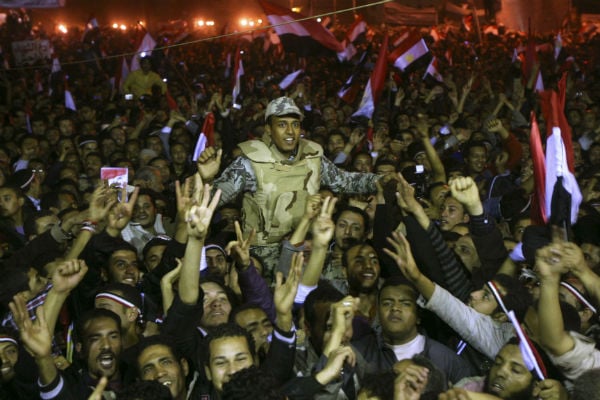 Des Égyptiens tenant un soldat sur la place Tahrir après la démission du président Hosni Moubarak et la remise du pouvoir à l'armée au Caire, le 11 février 2011