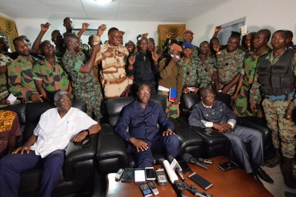 Des soldats mutins entourent Alain-Richard Donwahi (assis, au centre), alors ministre de la Défense, après les négociations de Bouaké, le 7 janvier 2017. © Sia KAMBOU/AFP