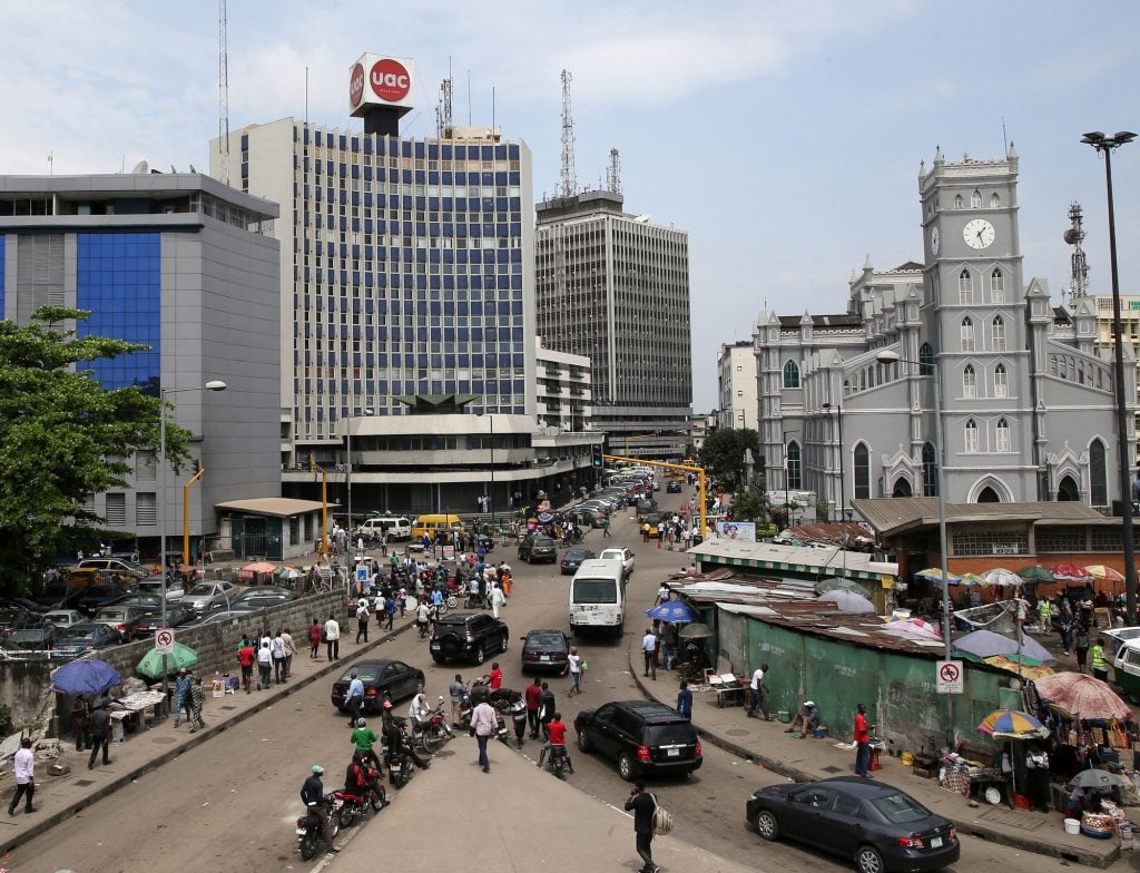 Pedestrians pass street traders in the business district of Lagos, Nigeria, on Monday, Oct. 26, 2015. Nigeria plans to create a $25 billion fund with public and private financing to modernize infrastructure and avoid a recession, Vice President Yemi Osinbajo said. Photographer: George Osodi/Bloomberg via Getty Images