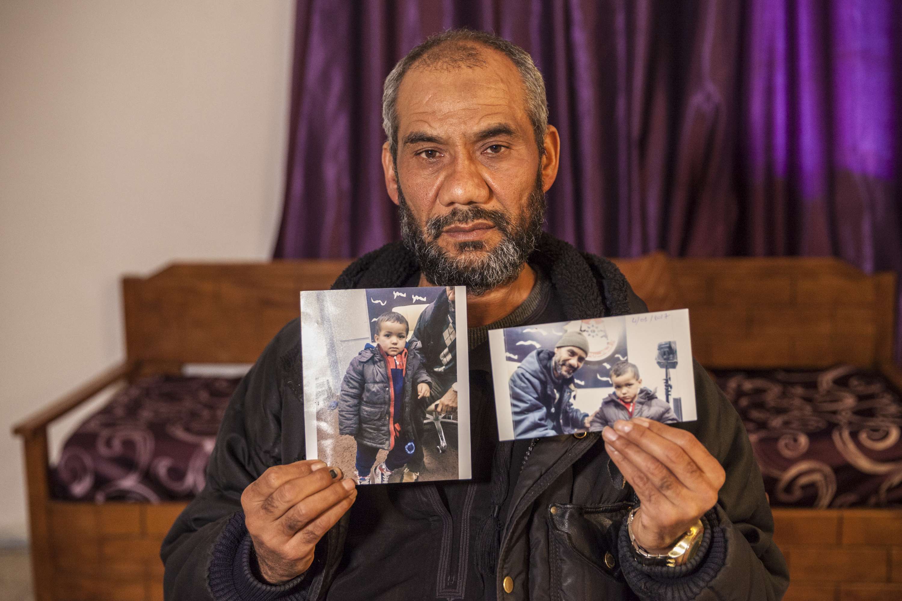 Le grand-père de Tamim avec une photo de l'enfant dont les parents sont décédés lors d'un bombardement américain, en 2016 en Libye.