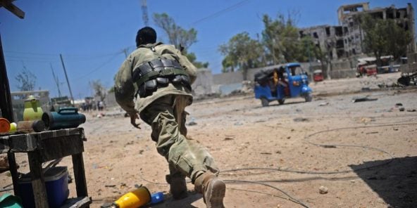 Un soldat somalien se met à l’abri pendant l’attaque de ministères par les islamistes shebab, le 23 mars 2019 à Mogadiscio.