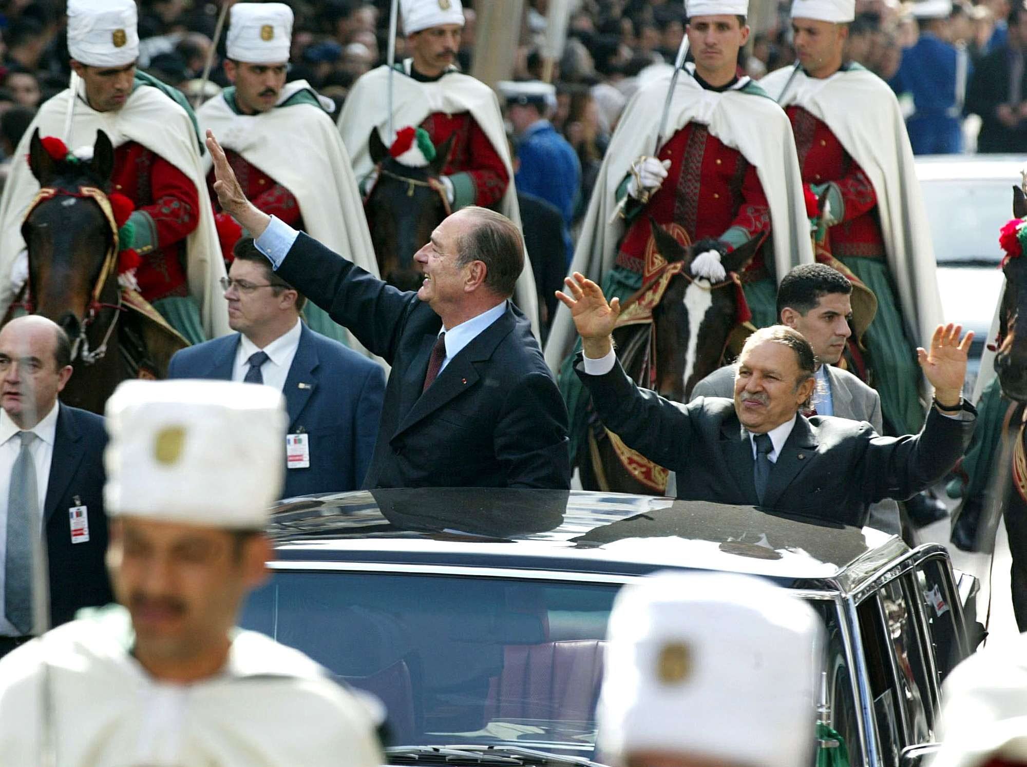 Le président français Jacques Chirac défilant dans les rues d'Alger aux côtés de son homologue Abdelaziz Bouteflika, en mars 2003.