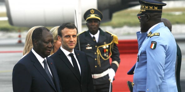 Le président français Emmanuel Macron (d) et le président de Côte d'Ivoire Alassane Ouattara, à l'aéroport d'Abidjan, le 20 décembre 2019.