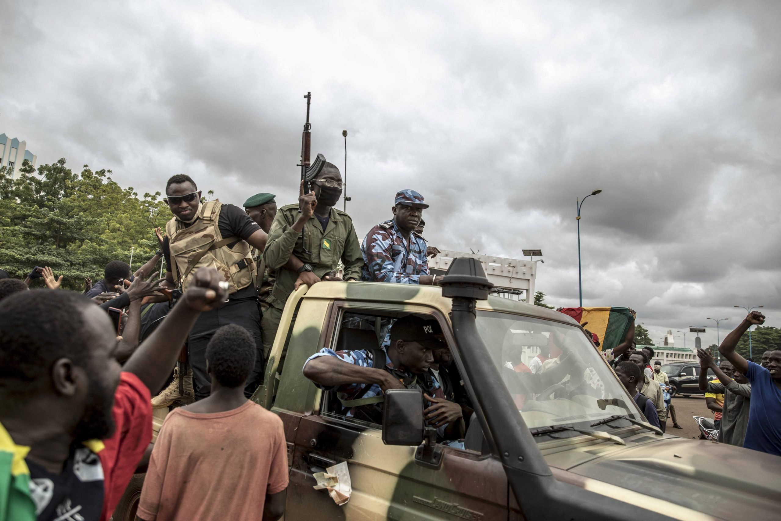 Des manifestants saluent le passage un convoi de militaires à Bamako, le 19 août 2020, au lendemain de la démission d'IBK.