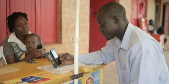 Un client reçoit de l’argent via le service WorldRemit, en Ouganda