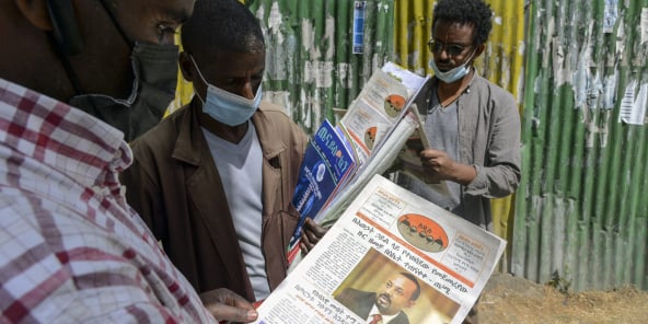 Des Éthiopiens lisent des journaux faisant état de la confrontation militaire en Éthiopie, le 7 novembre 2020 à Addis Abeba.