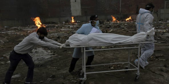 Le corps d’une victime du Covid-19 est transporté pour être incinéré dans un terrain transformé en crématorium à New Delhi, en Inde, le 6 mai 2021.